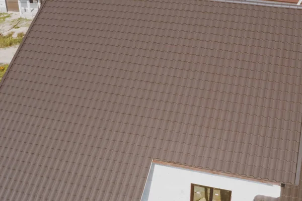 Mattonelle di metallo marrone sul tetto della casa. tetto in metallo ondulato — Foto Stock