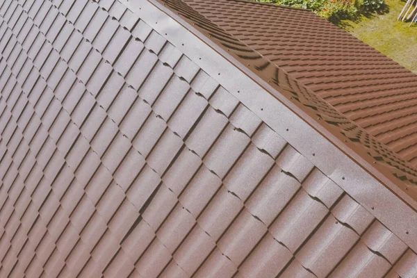 Evin çatısında kahverengi metal fayans var. Oluklu metal çatı — Stok fotoğraf
