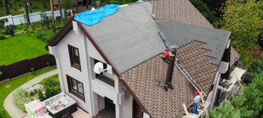 İşçi evin çatısını kuruyor. Kurulum