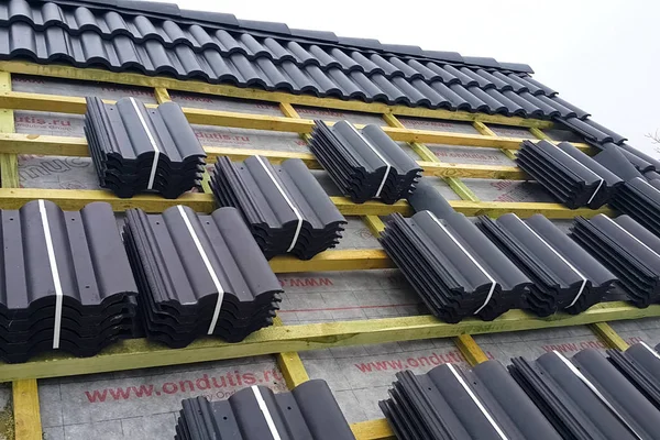 Εγκατάσταση της οροφής του σπιτιού από κεραμικά μαύρα πλακίδια. — Φωτογραφία Αρχείου