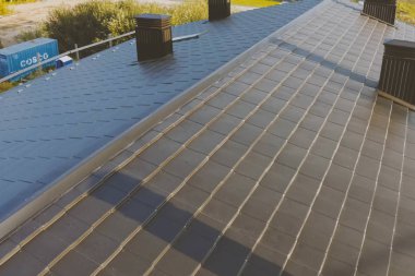 Metalden yapılmış endüstriyel bir binanın koyu gri çatısı. Corrugat