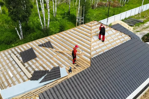 Worker does the installation of the roof of house. Installation 