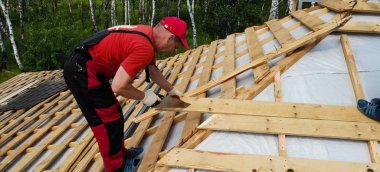 İşçi evin çatısını kuruyor. Kurulum