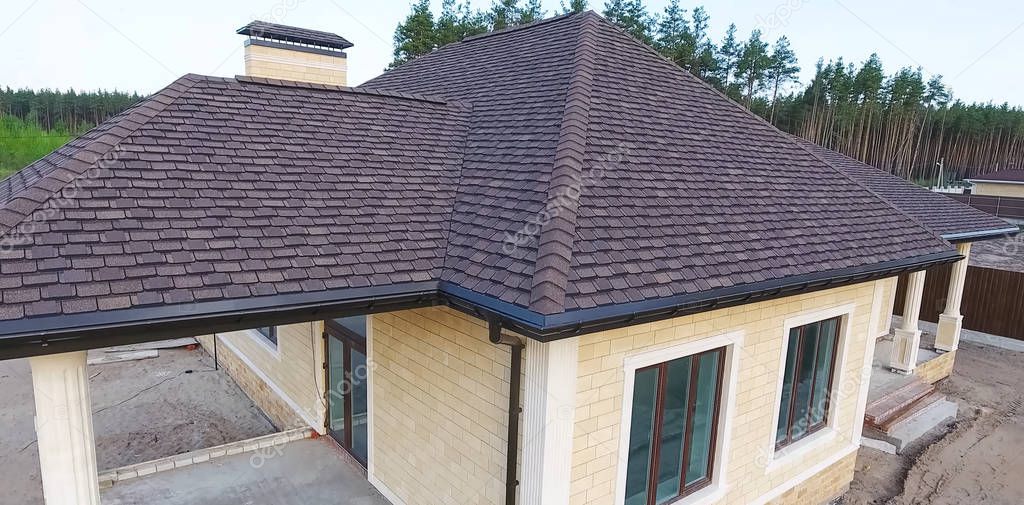 Bituminous tile for a roof. House with a roof from a bituminous tile. a roof from a bituminous tile. Moder