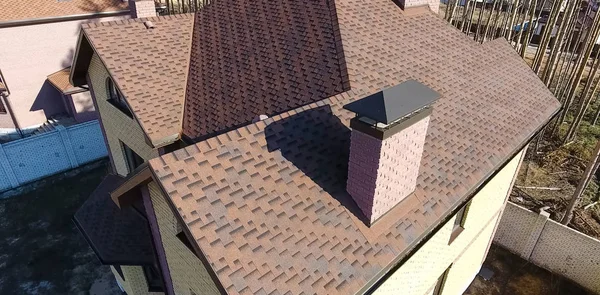 Битумная плитка для крыши. Дом с крышей из битумной плитки. крыша из битумной плитки. Мо — стоковое фото