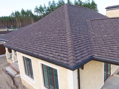 Çatı için küçük fayanslar. Bituminous 'un çatısına sahip bir ev