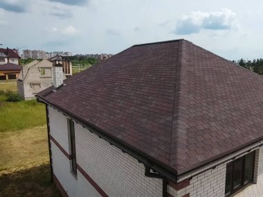 Çatı için küçük fayanslar. Bituminous 'un çatısına sahip bir ev