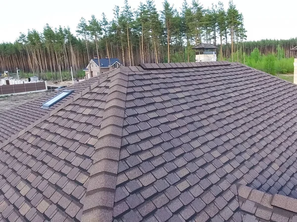 Telha betuminosa de um telhado. Casa com telhado de betuminoso — Fotografia de Stock