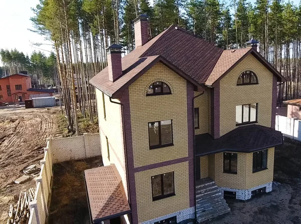 Nova casa de tijolos. Telha betuminosa de um telhado. Casa com telhado — Fotografia de Stock