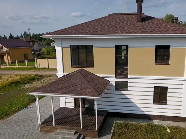Nova casa de tijolos. Telha betuminosa de um telhado. Casa com telhado — Fotografia de Stock