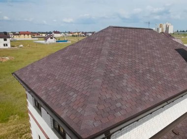 Çatı için küçük fayanslar. Bituminous 'un çatısına sahip bir ev