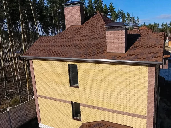 Yeni tuğla ev. Çatı için küçük fayanslar. Çatısı olan ev. — Stok fotoğraf
