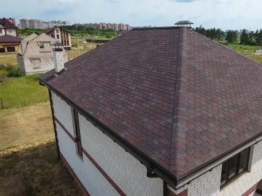 Çatı için küçük fayanslar. Bituminous 'un çatısına sahip bir ev