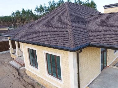 Çatı için küçük fayanslar. Bituminous 'un çatısına sahip bir ev