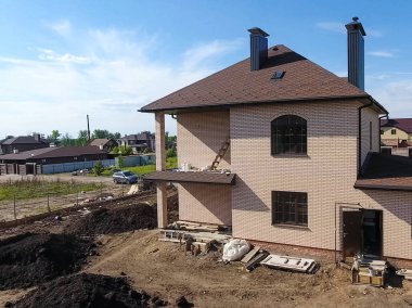 Yeni tuğla ev. Çatı için küçük fayanslar. Çatısı olan ev.