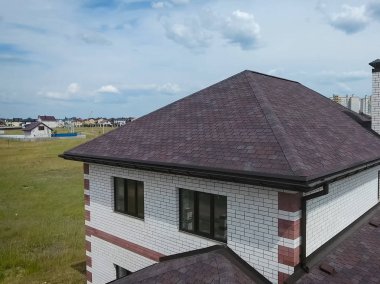 Çatı için küçük fayanslar. Bituminous 'un çatısına sahip bir ev