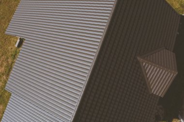 Evin çatısında kahverengi metal fayans var. Oluklu metal çatı