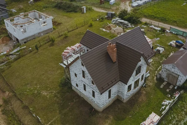 Casa nova, cujo telhado é feito de metal. Casa de campo no campo . — Fotografia de Stock