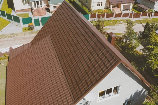 家の屋根の上に茶色の金属タイル。段ボール金属屋根 — ストック写真