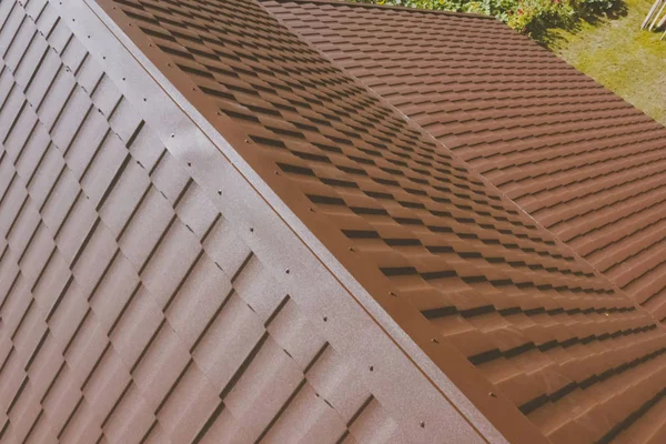 Braune Metallziegel auf dem Dach des Hauses. Wellblechdach — Stockfoto