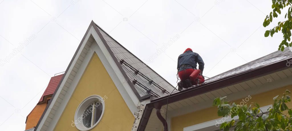 Worker does the installation of the roof of house. Installation