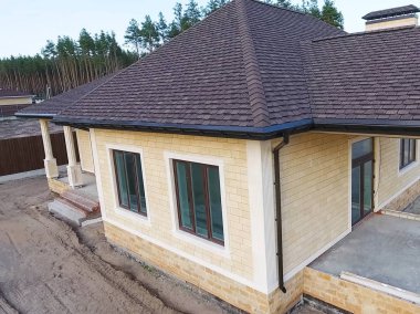 Çatı için küçük fayanslar. Bituminous 'un çatısına sahip bir ev