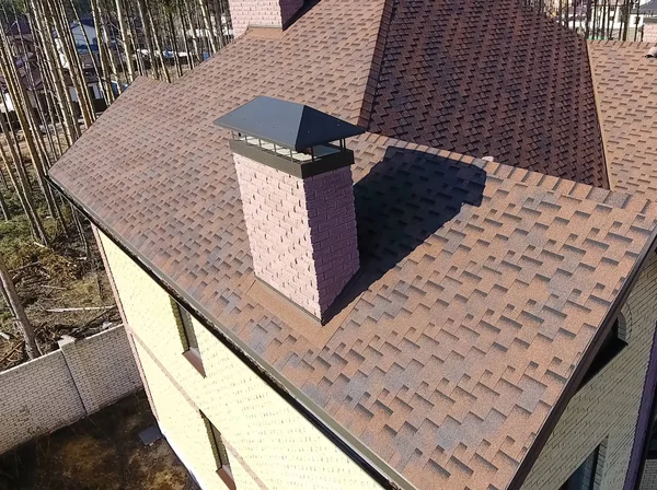 Baldosas bituminosas para un techo. Casa con un techo de un bituminoso — Foto de Stock