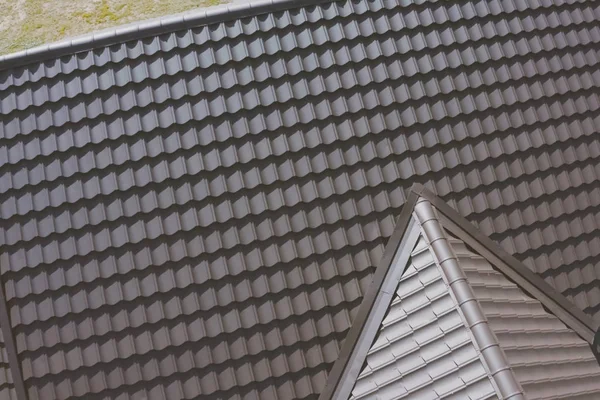 Brown metal tile on the roof of the house. Corrugated metal roof