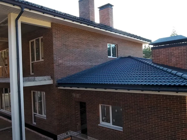 New brick house. House with ceramic tile roof. cement-sand roof