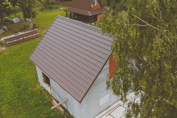 Brun metallplatta på taket av huset. Korrugerat metalltak — Stockfoto