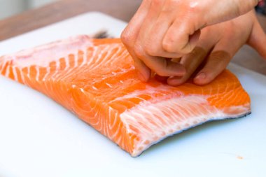 Kırmızı balığın küçük kemiklerinden cımbız çıkarıyorum..