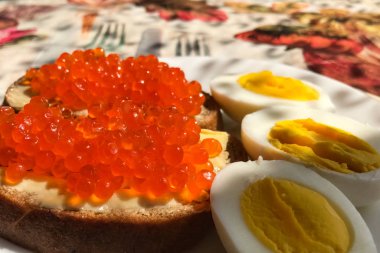 Kırmızı havyarlı sandviç, haşlanmış yumurta, kahve fincanı. Günaydın.