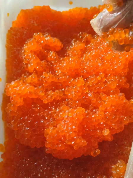 Caviar rojo en un recipiente de plástico. Caviar de salmón, comida dietética . — Foto de Stock