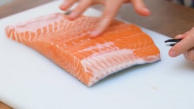 Bir parça kırmızı balıktan küçük kemik cımbızı çıkarıyorum..