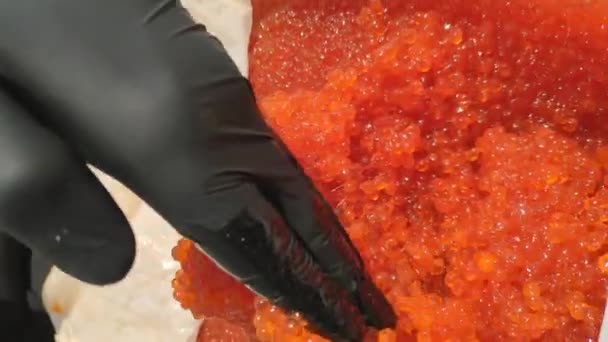 Eieren Mengen Met Een Handschoenhand Rode Kaviaar Een Plastic Container — Stockvideo