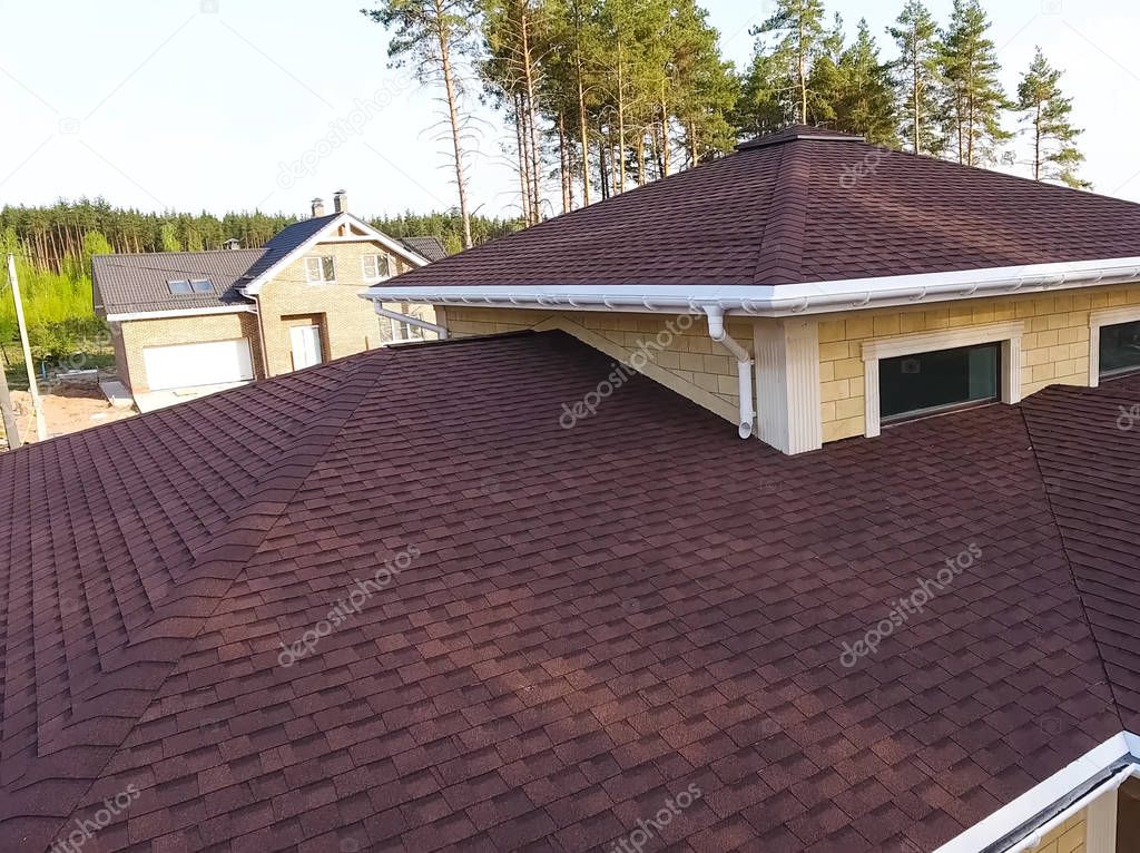Bituminous tile for a roof. House with a roof from a bituminous