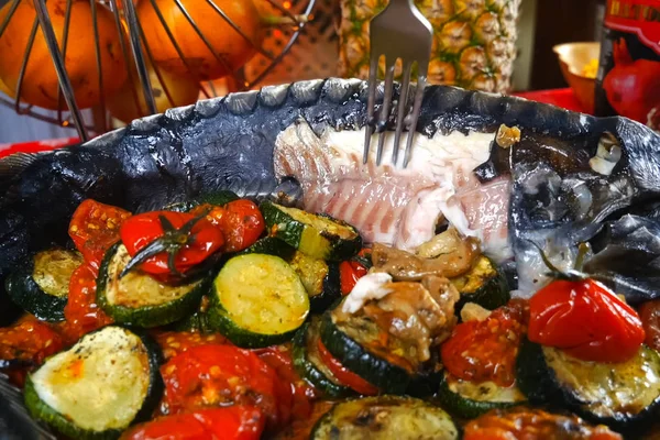 Baked sturgeon with vegetables. Delicatessen on table.