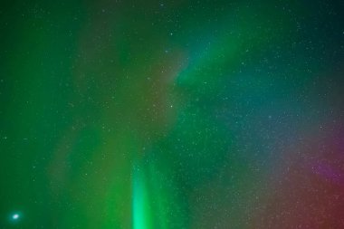 Kuzey gökyüzünde Aurora Borealis. Üst atmosferde hava parçacıklarının iyonlaşması.