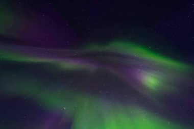 Kuzey gökyüzünde Aurora Borealis. Üst atmosferde hava parçacıklarının iyonlaşması.