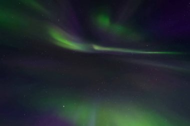 Kuzey gökyüzünde Aurora Borealis. Üst atmosferde hava parçacıklarının iyonlaşması.