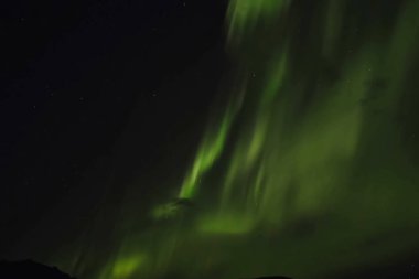 Kuzey gökyüzünde Aurora Borealis. Üst atmosferde hava parçacıklarının iyonlaşması.