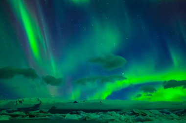 Kuzey gökyüzünde Aurora Borealis. Üst atmosferde hava parçacıklarının iyonlaşması.