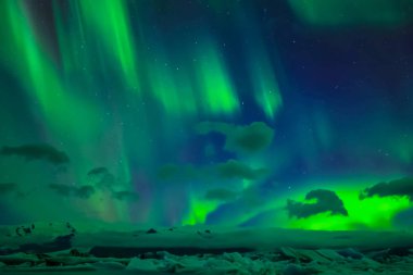 Kuzey gökyüzünde Aurora Borealis. Üst atmosferde hava parçacıklarının iyonlaşması.