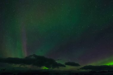 Kuzey gökyüzünde Aurora Borealis. Üst atmosferde hava parçacıklarının iyonlaşması.