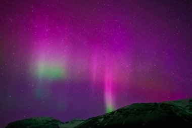 Kuzey gökyüzünde Aurora Borealis. Üst atmosferde hava parçacıklarının iyonlaşması.