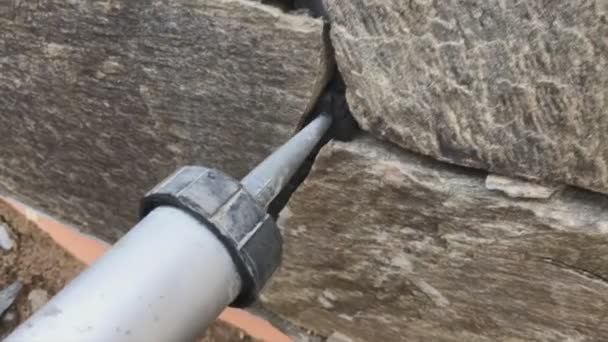 Singing gaps between the wild stone on the cladding of the foundation. Facing the foundation of a house — Stock Video