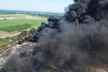 Yağ depolama yangını. Tank çiftliği yanıyor, siyah duman çıkıyor.