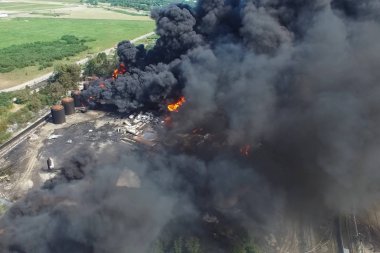 Yağ depolama yangını. Tank çiftliği yanıyor, siyah duman çıkıyor.
