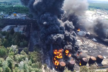 Yağ depolama yangını. Tank çiftliği yanıyor, siyah duman çıkıyor.