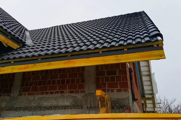 Instalación del techo de la casa a partir de baldosas negras de cerámica . — Foto de Stock